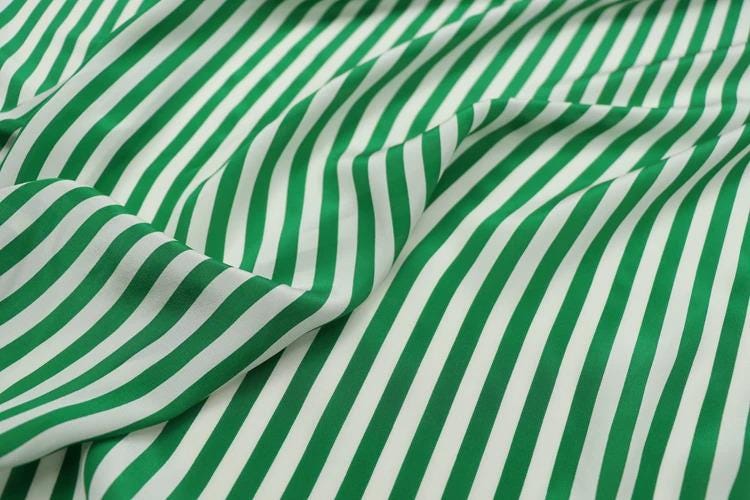 a close-up view of a fabric with green and white striped patterns.