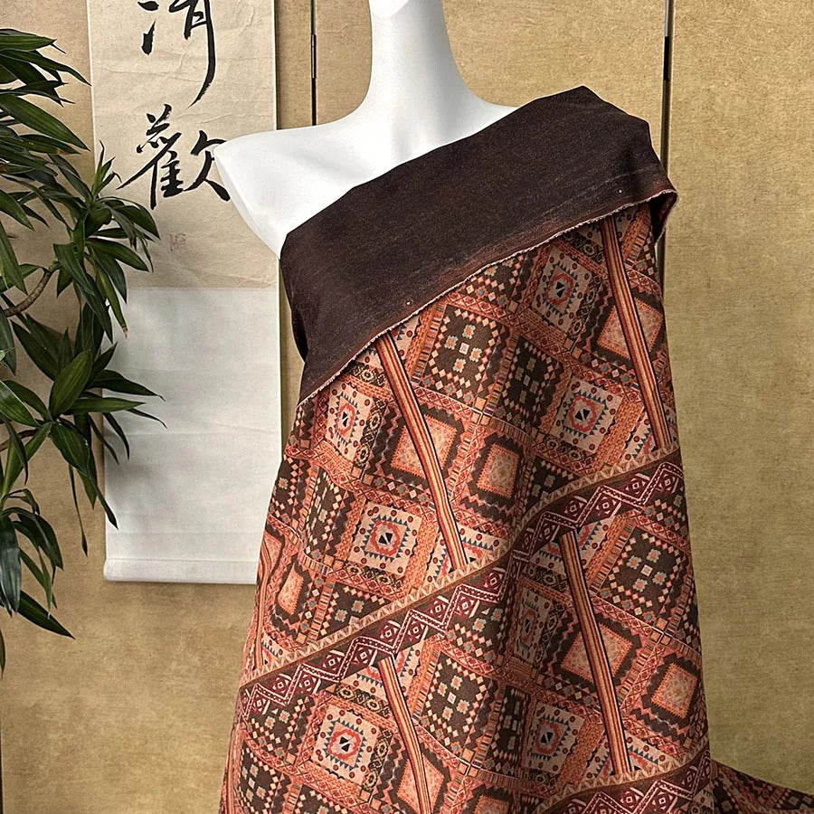 A mannequin wearing a brown and orange patterned fabric draped over its body.