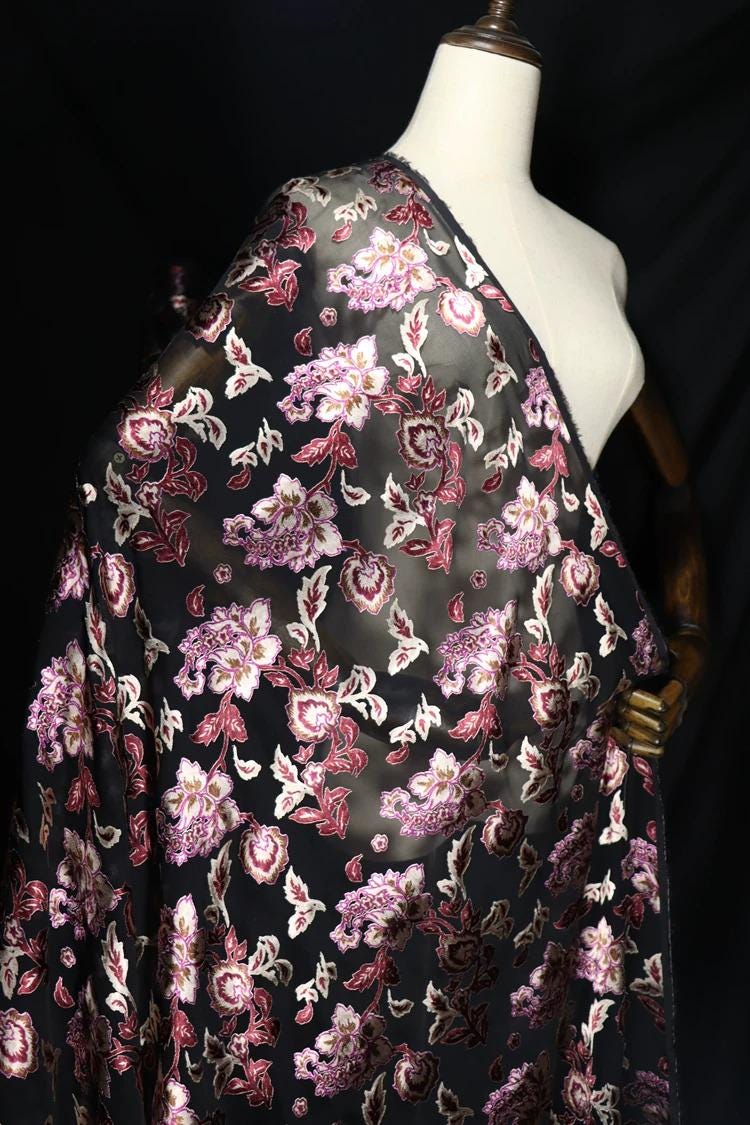 a mannequin wearing a black and pink floral fabric draped over it.
