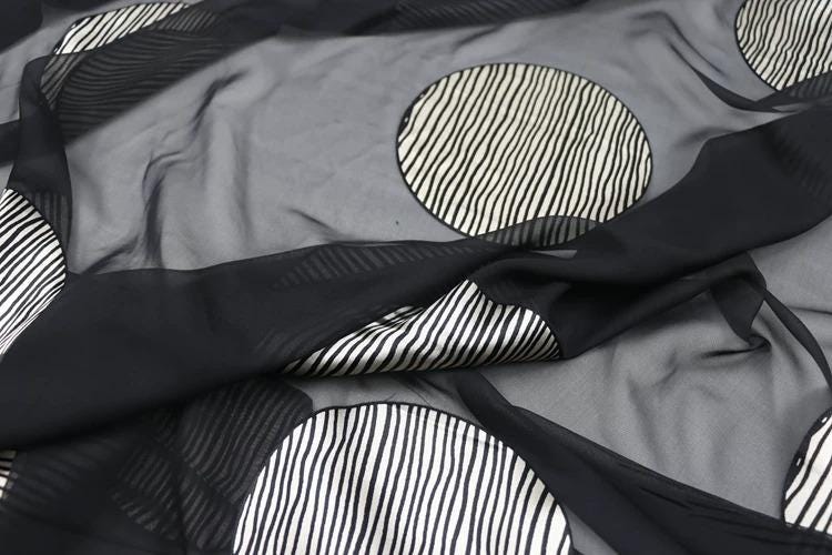 a close-up view of a fabric with a black and white striped pattern, featuring circular shapes.