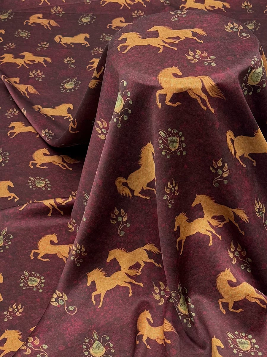a fabric with a repeating pattern of gold horses on a dark red background.