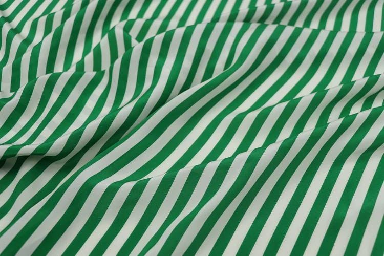 a close-up view of a fabric with a repeating pattern of green and white stripes.