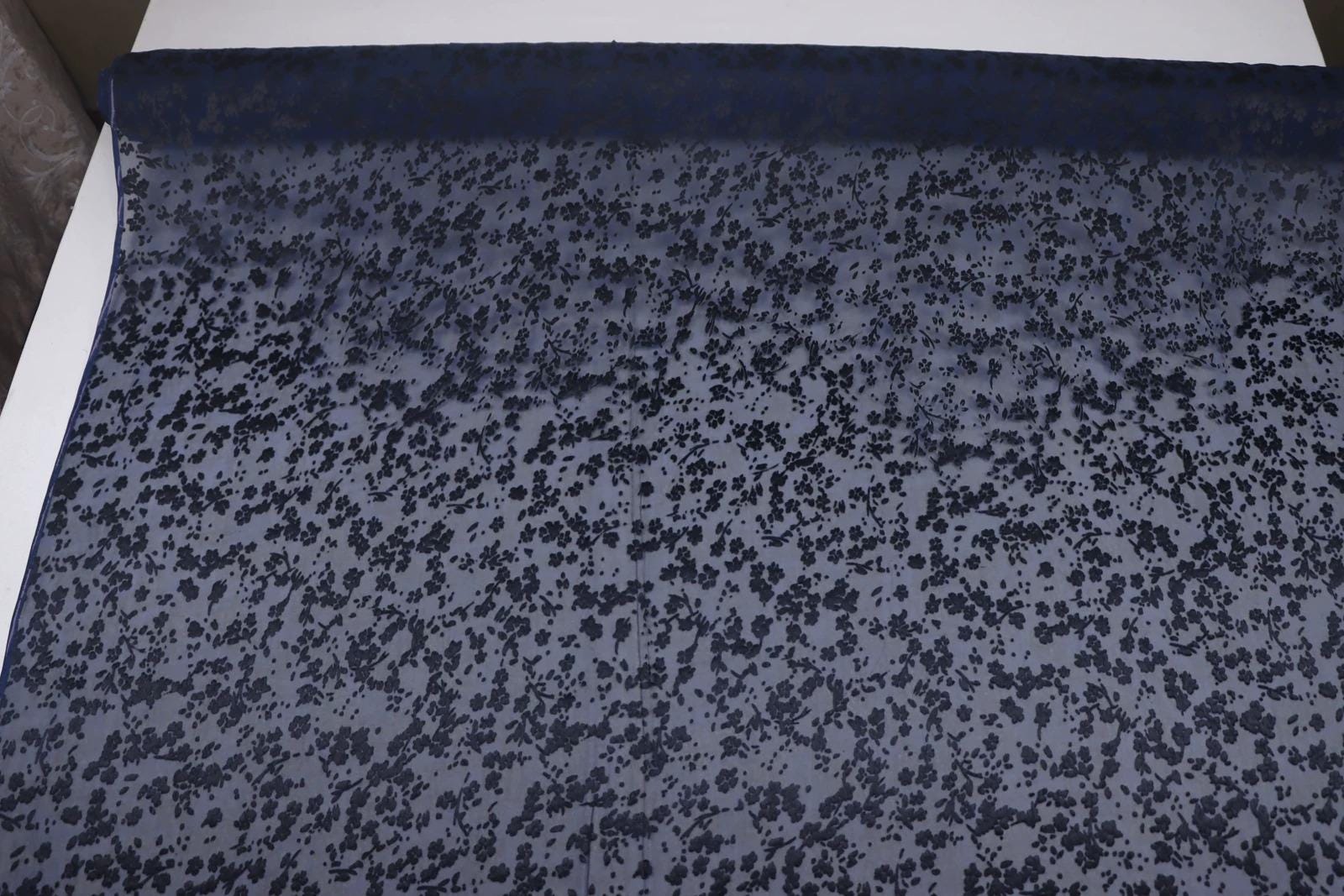 a close-up view of a fabric with a dark blue floral pattern.