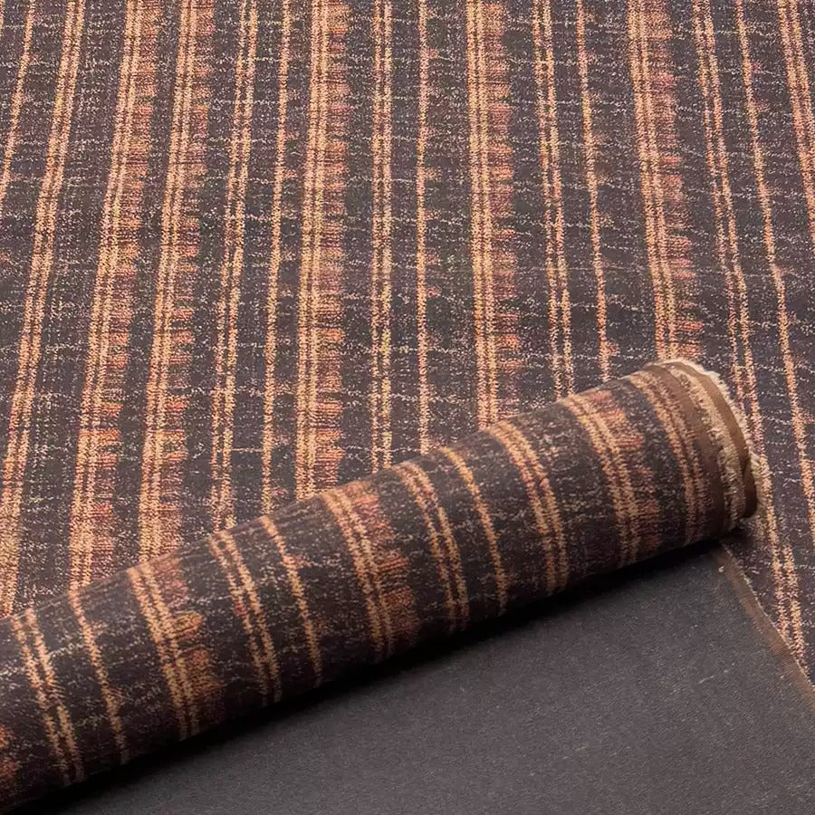 a close-up view of a textured fabric with a striped pattern in shades of brown and orange.