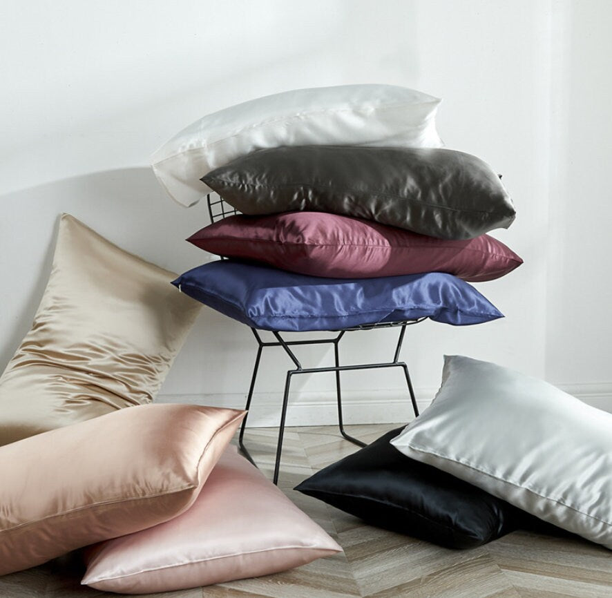 a pile of pillows sitting on top of a wooden floor