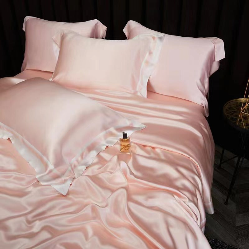 a bed with a pink comforter and pillows