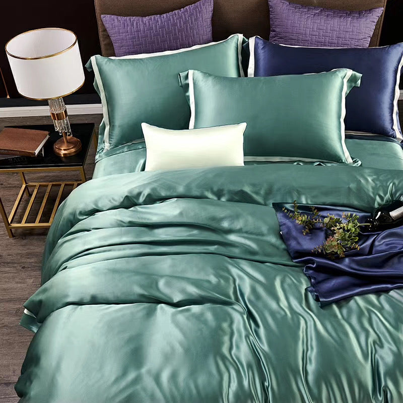 a bed with a green comforter and pillows