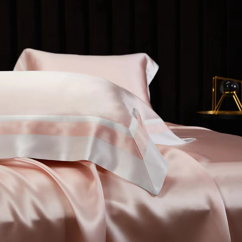 a close up of a bed with a pink comforter