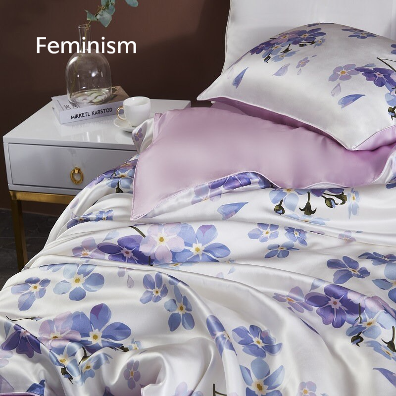 a bed with a white and purple comforter and pillows