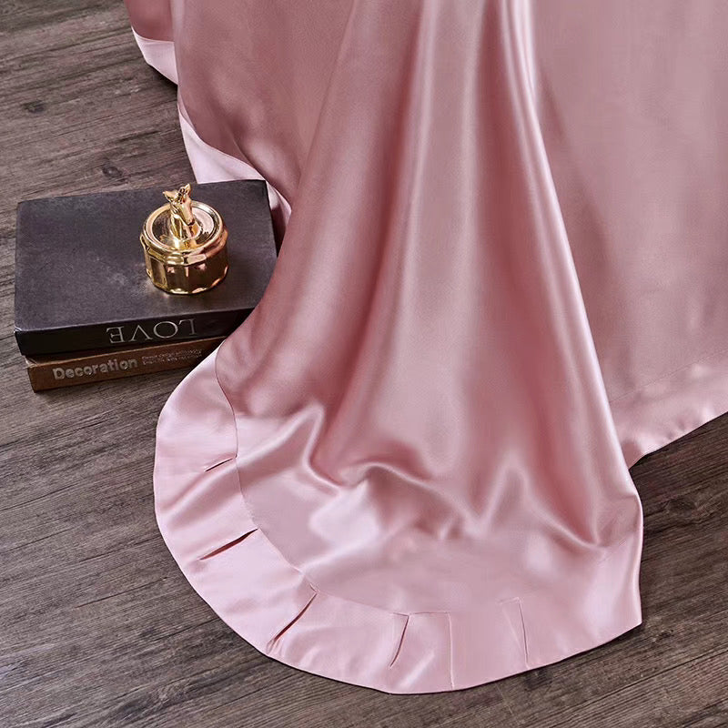 a bed with a pink comforter and a gold ring