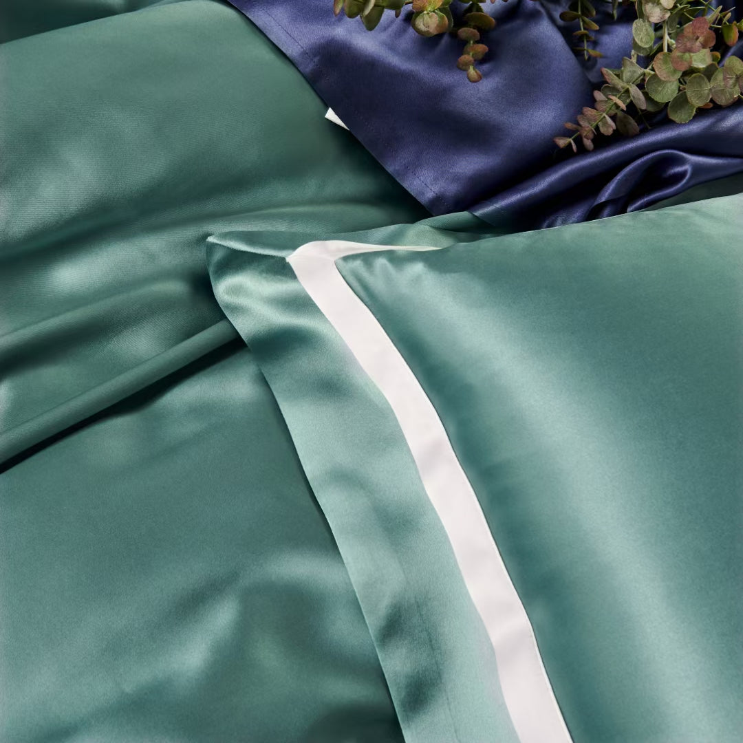 a close up of a bed with a blue and green comforter