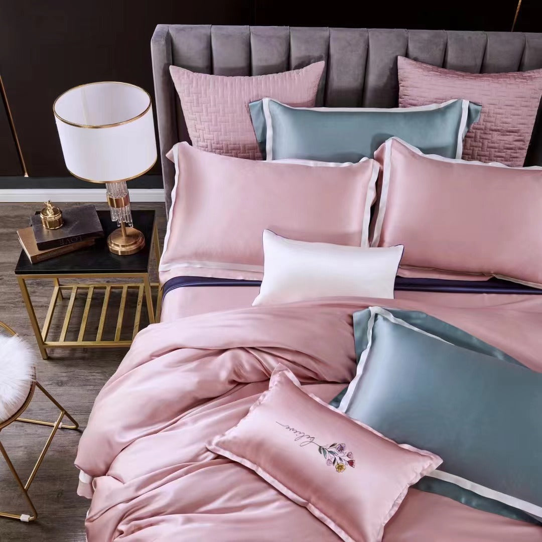 a bed with pink and blue sheets and pillows